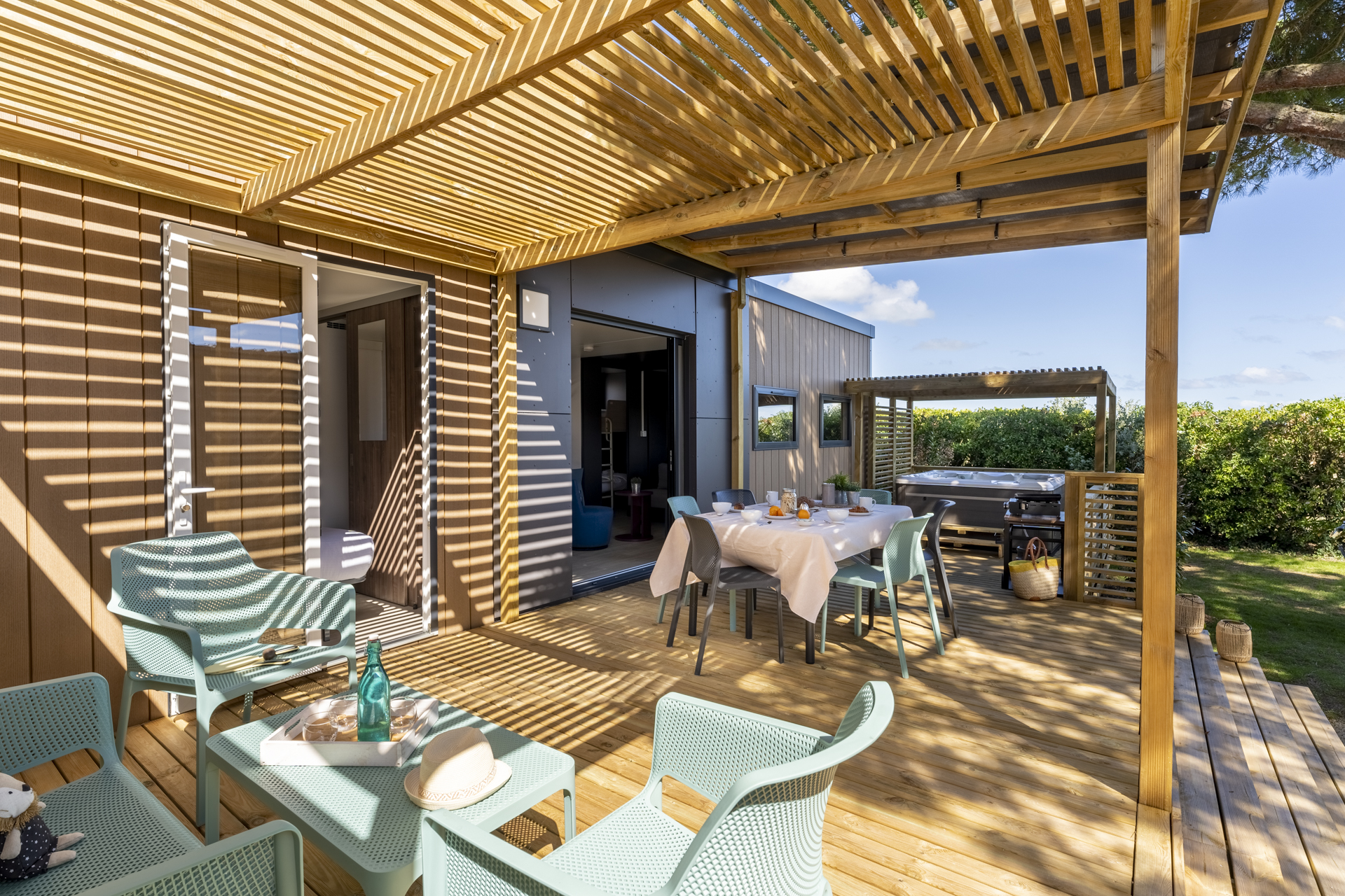 Terrasse ensoleillée avec mobilier extérieur et jacuzzi.
