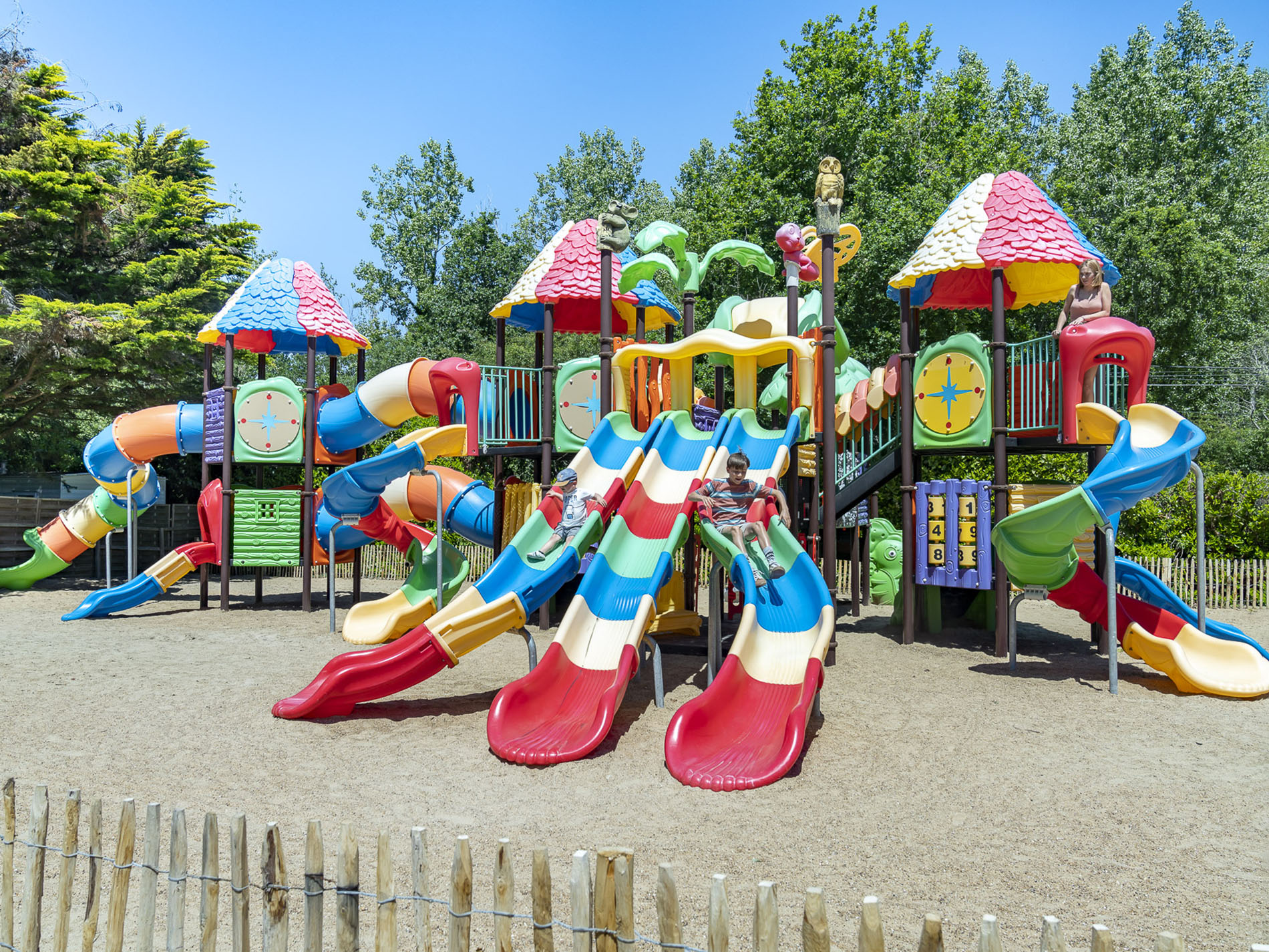 Terrain de jeux coloré avec toboggans et tours.