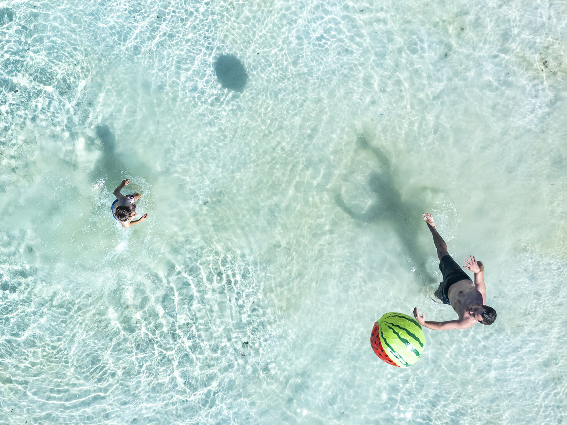 Personnes jouant avec ballon dans l'eau turquoise