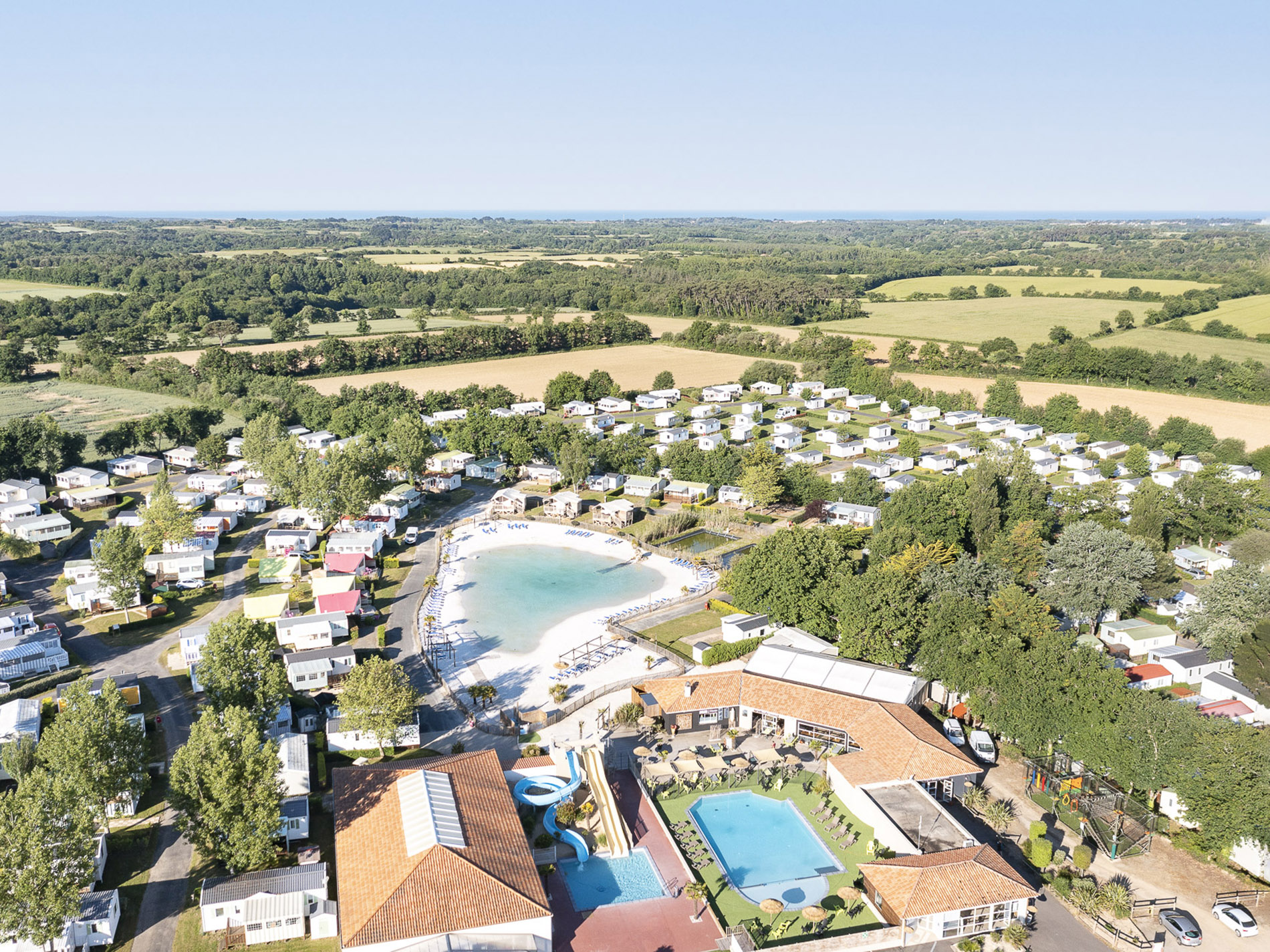 Vue aérienne d'un camping avec piscine et étang