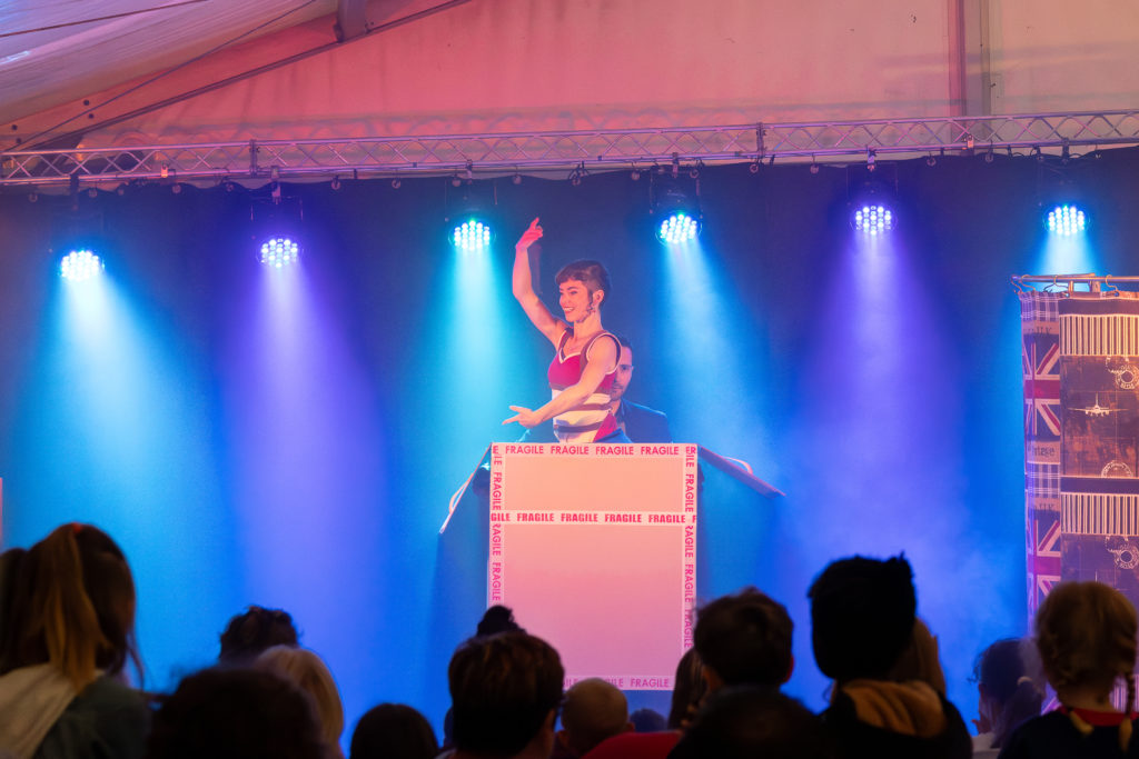 Spectacle de magie avec boîte et public.