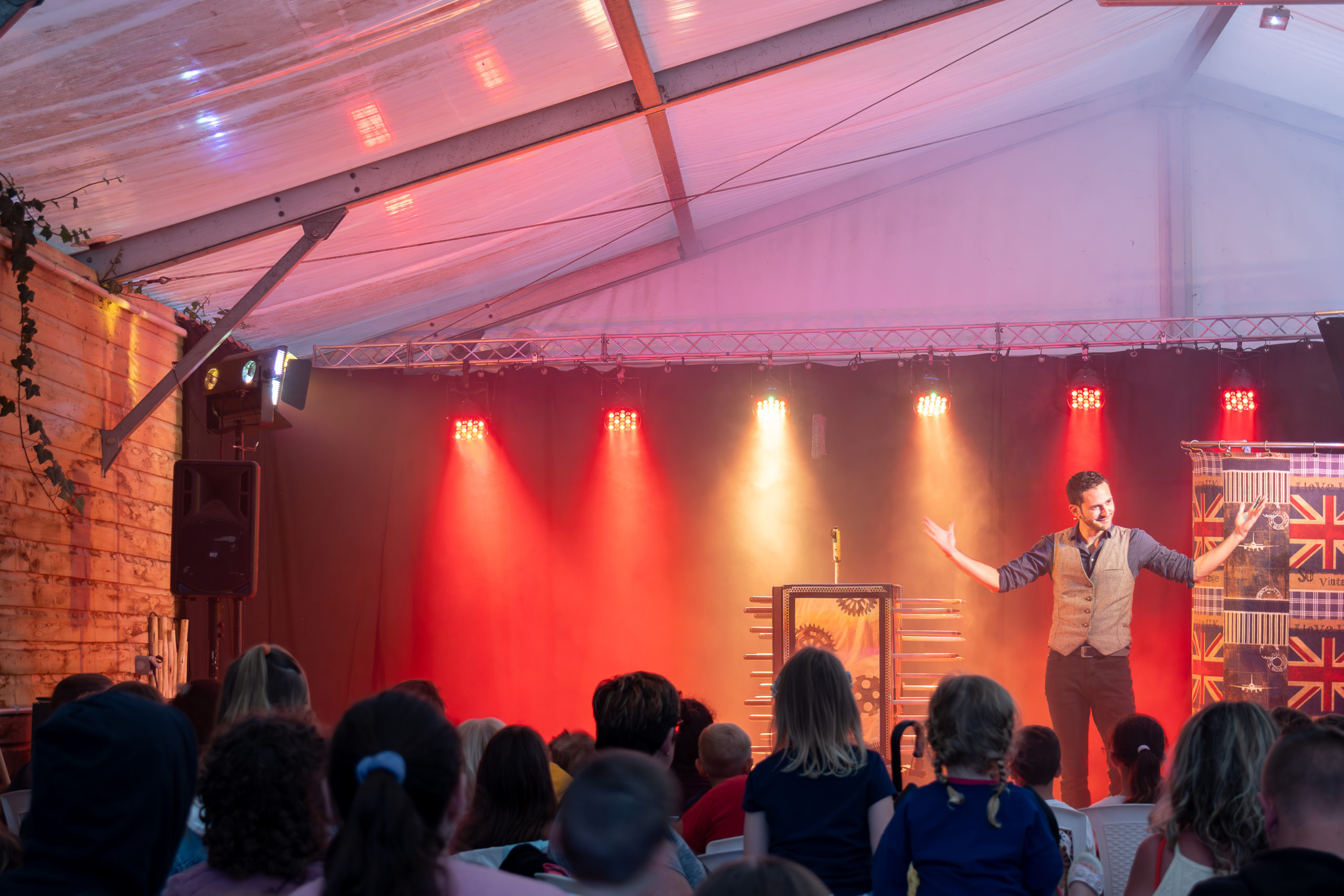 Spectacle de magie sous tente avec public attentif.