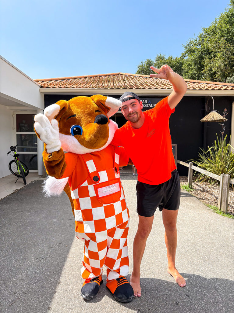 Personne avec mascotte en extérieur ensoleillé.