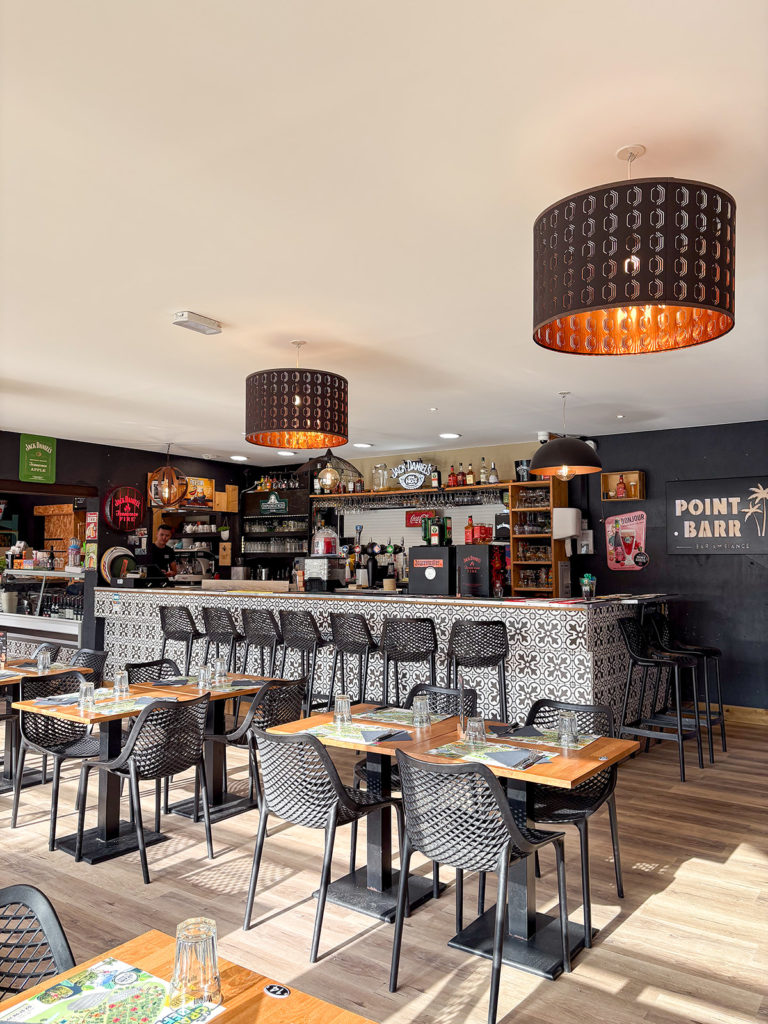 Intérieur moderne d'un bar avec des tables et chaises.