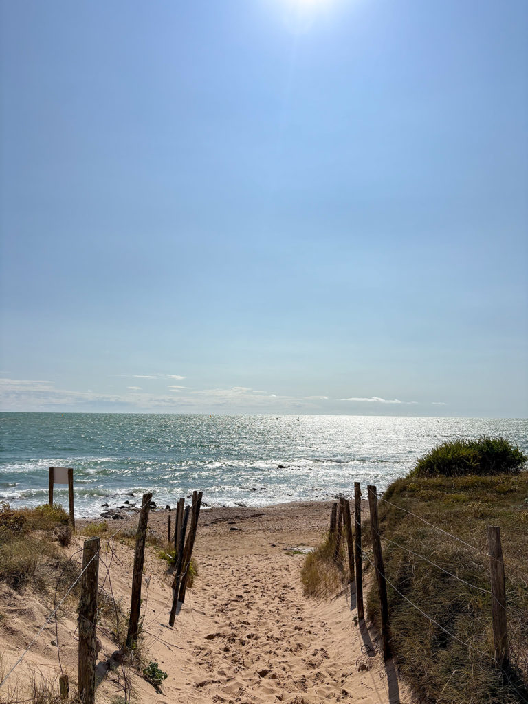 Sentier vers la plage ensoleillée au bord de mer.