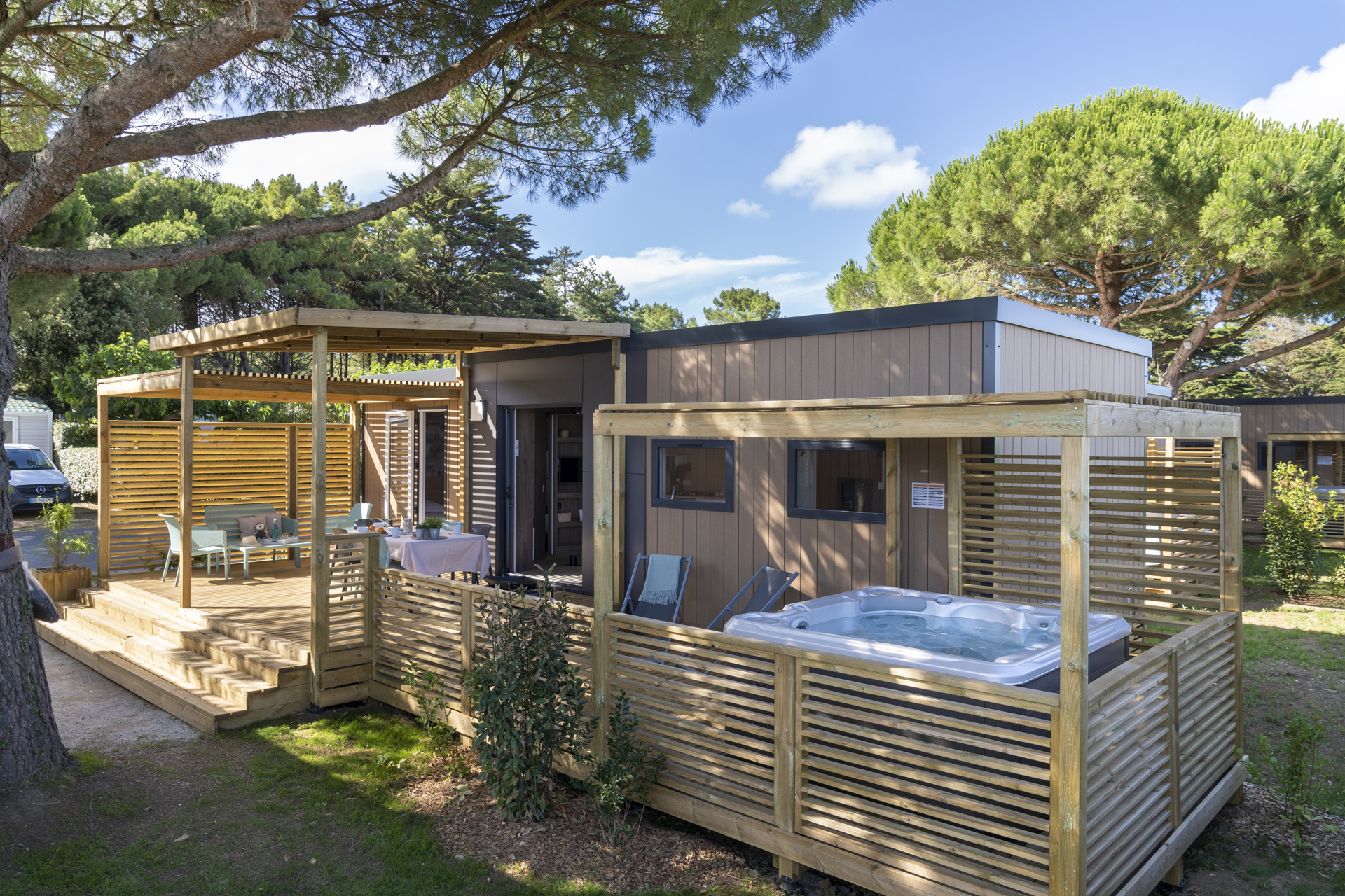 Chalet moderne avec terrasse et jacuzzi au camping.