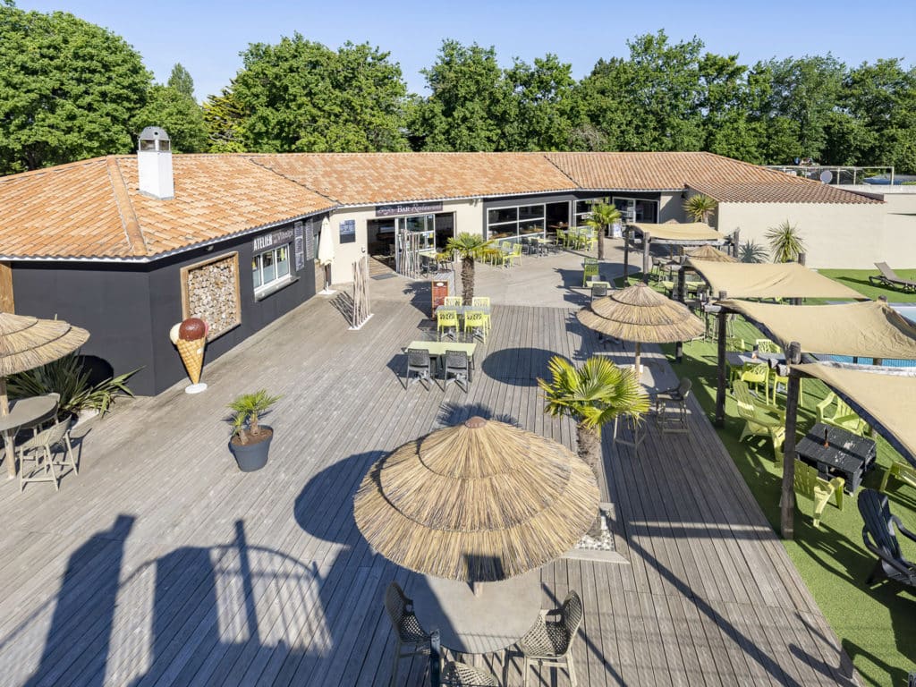 Terrasse d'un restaurant en bois avec parasols et chaises