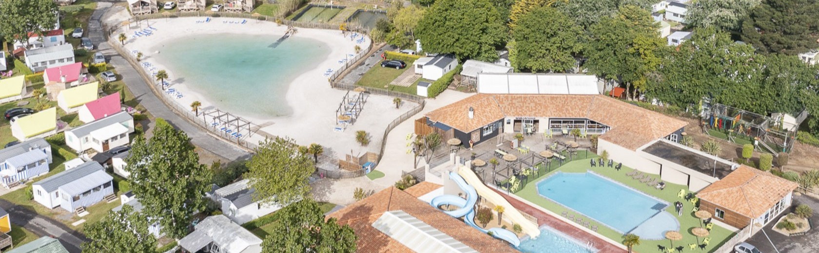 Vue aérienne d'un complexe avec plage et piscine.