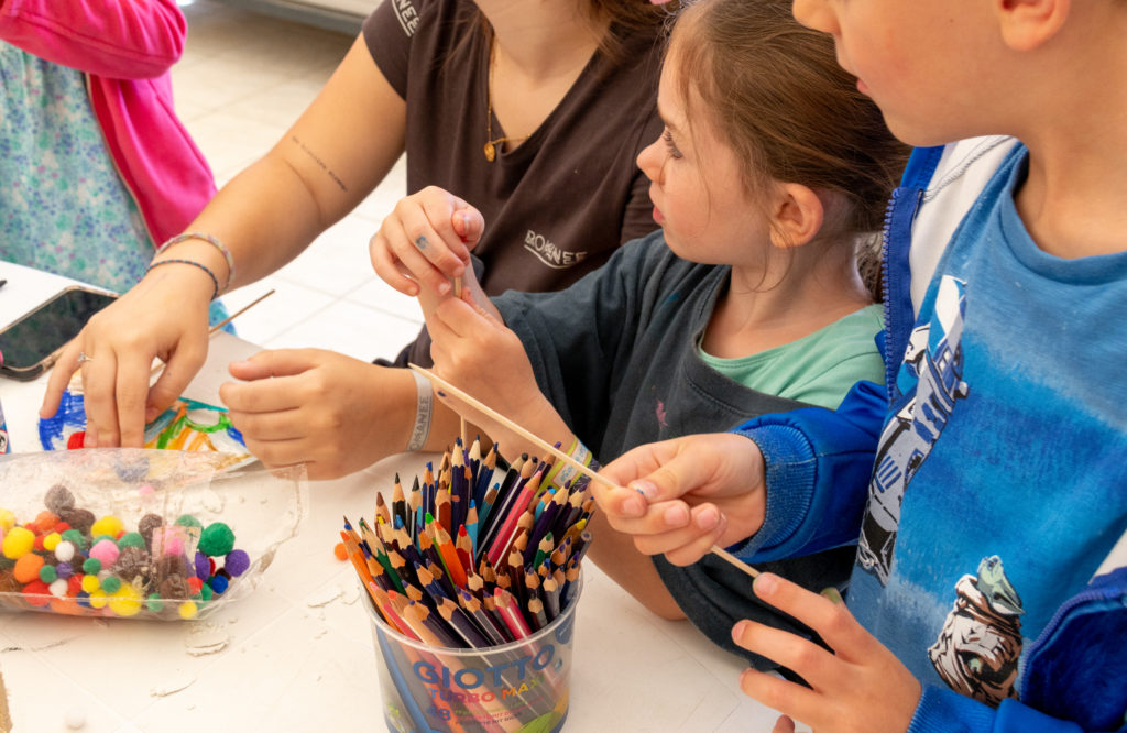 Enfants participant à un atelier créatif avec crayons.