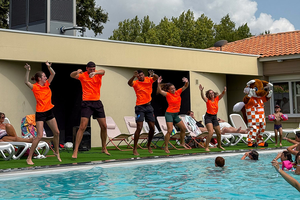 Animateurs dansants près de la piscine, ambiance estivale.