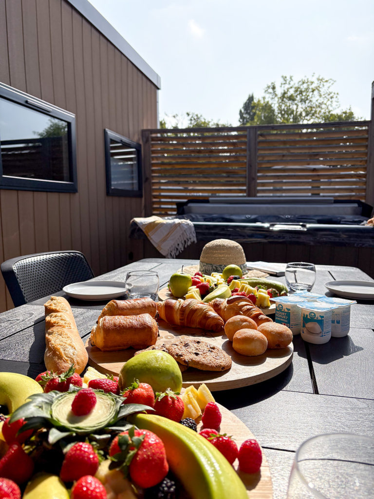 Délicieux petit-déjeuner en terrasse avec viennoiseries et fruits.